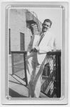 Physician in a White Suit Leaning on Fence by Memorial Hospital System